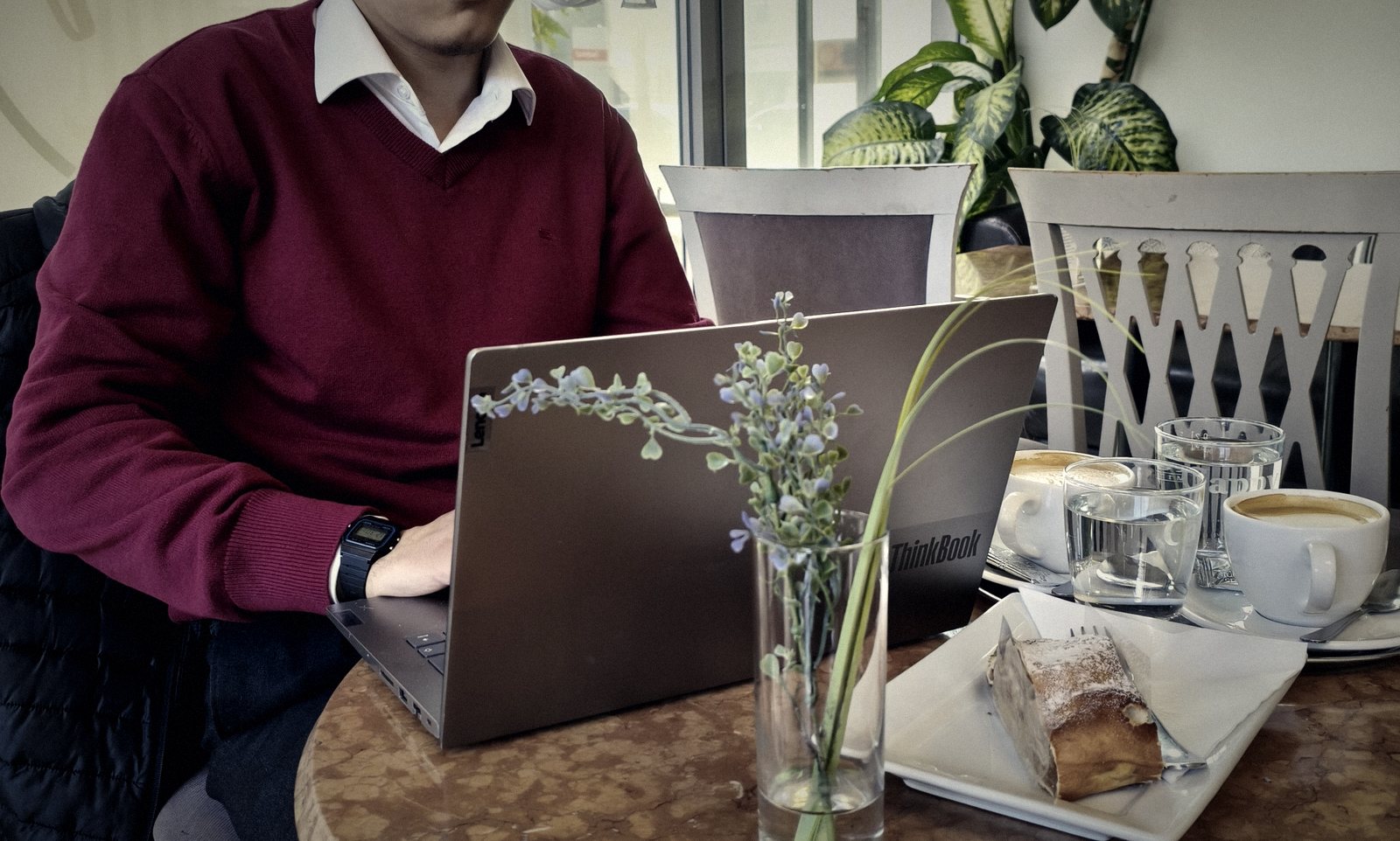 Arbeit am Laptop im Kaffeehaus, mit Melange und Strudel am Tisch
